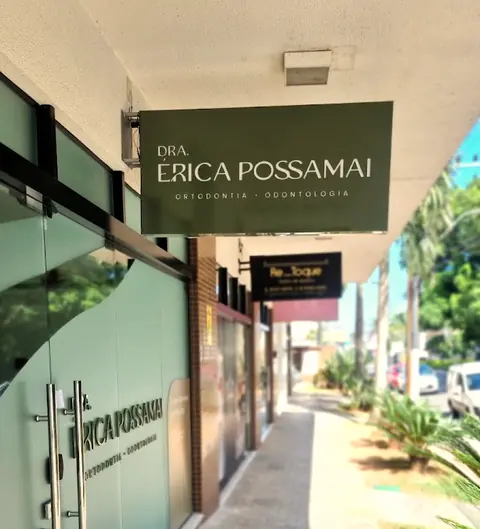 Letreiro verde do consultório da Dra. Érica Possamai, sobre a porta de vidro